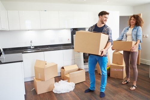 Specialist movers relocating a grand piano with protective equipment